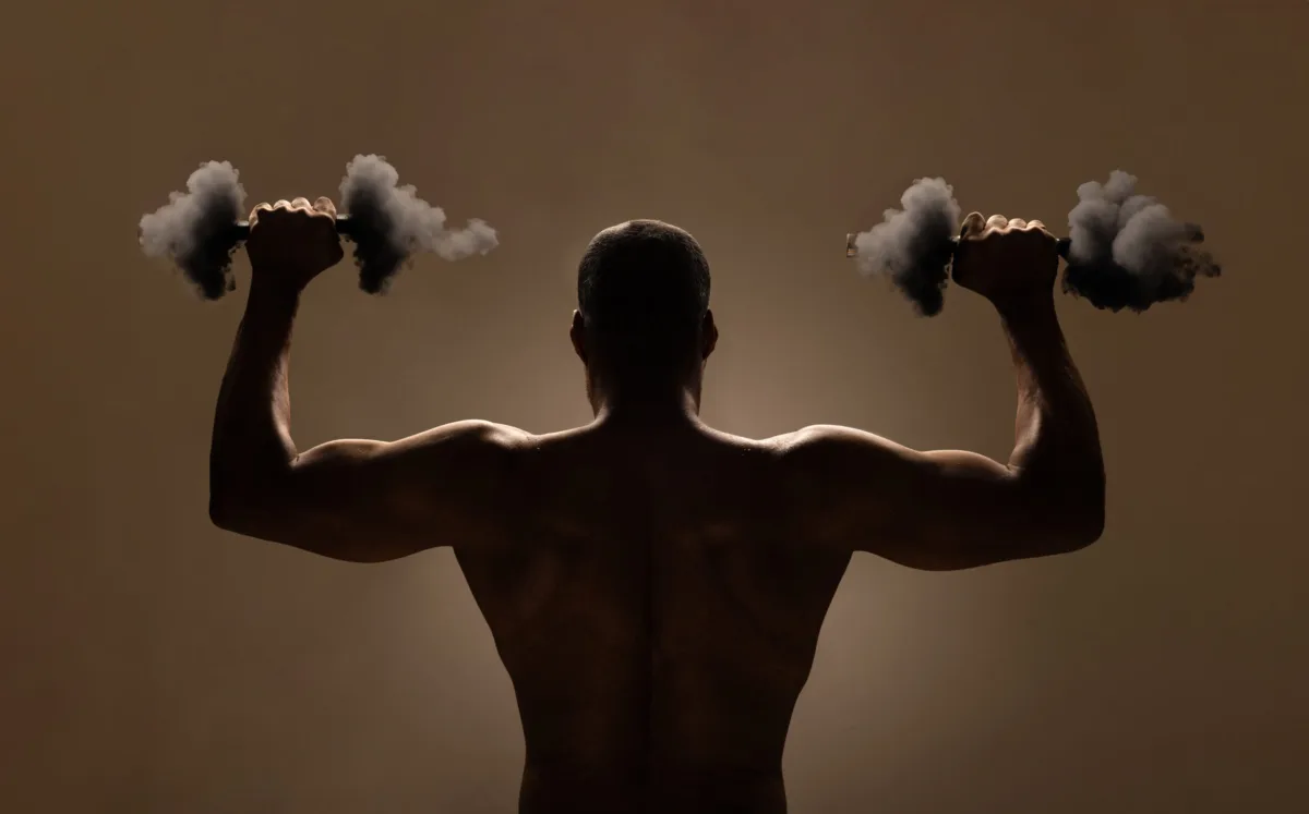A man seen from behind lifts dumbbells made of clouds