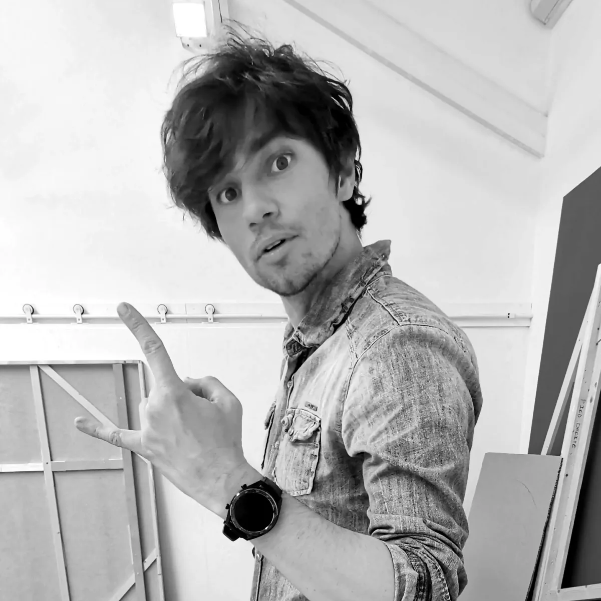 Charles-Édouard Gil in his studio, pulling a rock-and-roll sign
